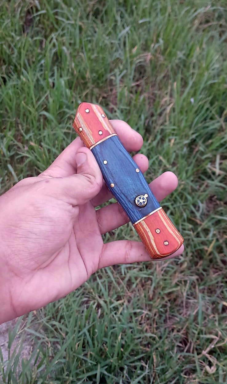 Close view of the blue dyed handle with amber bolsters, brass pins, and a mosaic pin.