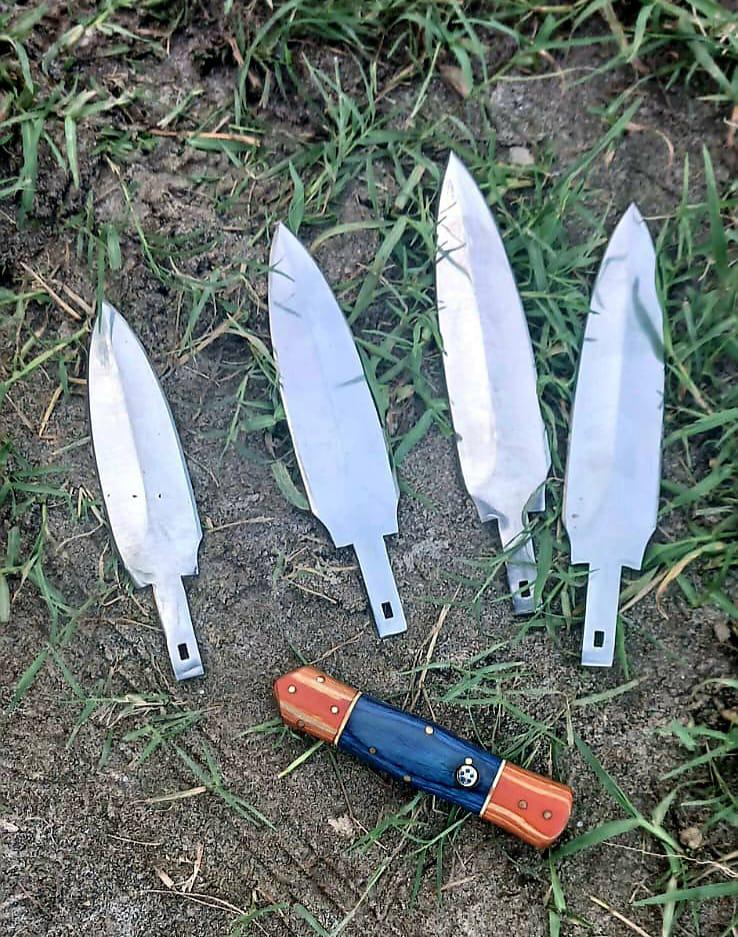 Four polished leaf blades and the template handle laid on dirt and grass.