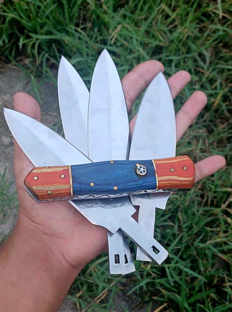 Hand holding the blue and amber template handle in front of four bright blades fanned in the grass.